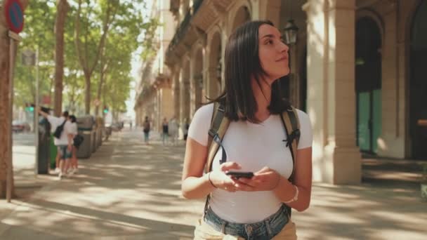 彼女の手で電話で通りを歩いている旅行者女性 — ストック動画