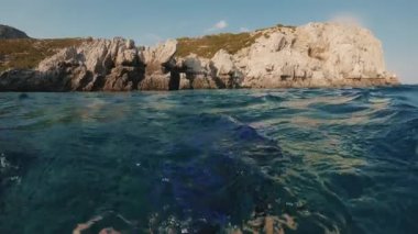 POV çekimi, yüzgeçleri su altında yüzgeçleriyle yüzen bir adam güzel kayalık kıyılardan uzaklaşıyor. Birinci şahıs videosu, adam Akdeniz 'in sularında yüzüyor.