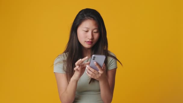 Leende Ung Kvinna Som Använder Mobiltelefon Isolerad Över Vit Bakgrund — Stockvideo