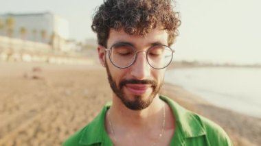 Genç adamın gözlerini açtığı ve kameraya gülümseyerek baktığı yakın plan.