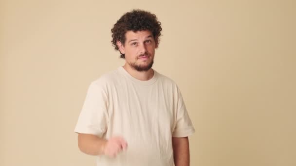 Homme Souriant Pointant Doigt Caméra Studio Sur Fond Beige — Video