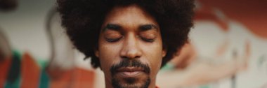 Genç Afro-Amerikan bir adamın yakın plan portresi şehir arka planında gözlerini açıyor. Kentsel yaşam.