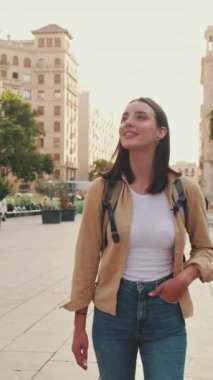 Kadın eski bir Avrupa şehrinin meydanında yürüyor