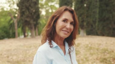 Kameraya bakarken gülümseyen yaşlı güzel kadının yakın çekimi.