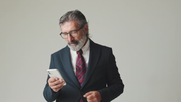Ευτυχής Επιχειρηματίας Κοιτάζοντας Smartphone Λήψη Καλά Νέα Απομονώνονται Γκρι Φόντο — Αρχείο Βίντεο