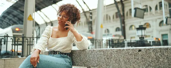 Mujer Joven Con Gafas Sentada Estación Hablando Smartphone Mujer Positiva —  Fotos de Stock