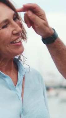 Kapalı, orta yaşlı aşık çift setin üzerinde dururken konuşuyor ve gülüyor.