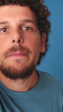 Yakın plan, video blogu için duyguları paylaşan adam, canlı yayın, mavi arkaplanda izole edilmiş.