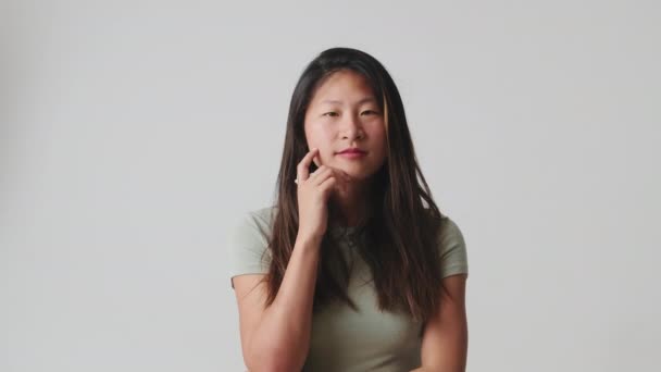 若い女性は情報に注意深くリストし スタジオの白い背景の上に隔離された合意のノード — ストック動画