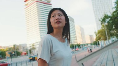 Güzel mutlu esmer kız günlük giysiler içinde merdivenlerden aşağı iniyor.