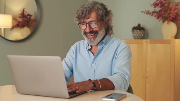 在客厅里戴眼镜的快乐老人通过视频通话在网上聊天 — 图库视频影像