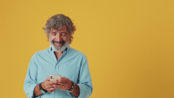 Akıllı Telefondan Mesaj Atan Yaşlı Gri Saçlı Adam Turuncu Arka — Stok video