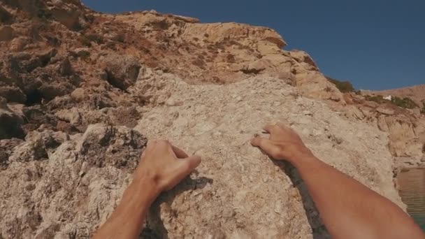Unterwasserschuss Mann Klettert Auf Küstenfelsen Sieht Sich Öffnet Die Hände — Stockvideo