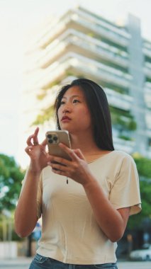 Gayri resmi giyinmiş güzel esmer kız, cep telefonunda kart başvurusu.
