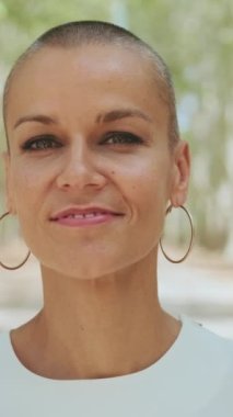 Yaklaş, güzel mutlu kadın gülümseyerek kameraya bakıyor.