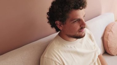 Yaklaş, rahat bir oturma odasında koltukta dinlenen adam.