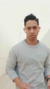 Sabah koşusunda kablosuz kulaklıklı genç adam.