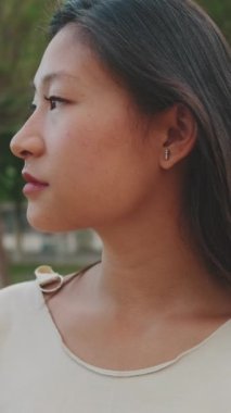 Genç bir kadın başını çevirir ve kameraya gülümseyerek bakar.