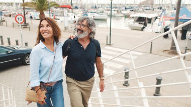 Mutlu orta yaşlı çift, emekli yaşlı çift birlikte gezmekten, kucaklaşmaktan, yatların arkasında konuşmaktan hoşlanırlar.