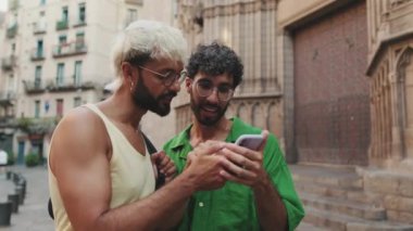 Homoseksüel çift eski şehrin caddesinde dururken cep telefonunda harita uygulaması kullanıyor
