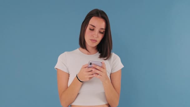 Jonge Vrouw Houden Met Behulp Van Mobiele Telefoon Geïsoleerd Blauwe — Stockvideo