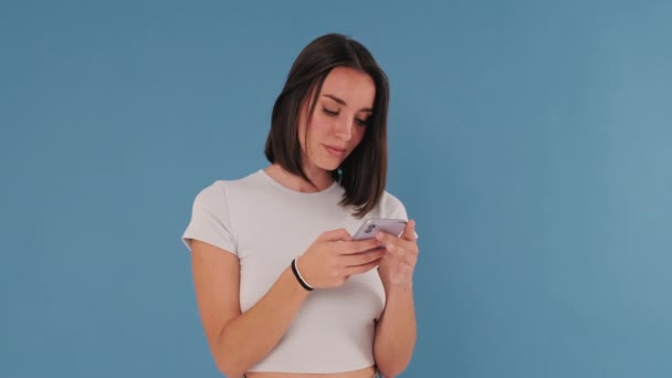 Verrassing Geluk Winnaar Opgewonden Meisje Met Mobiele Telefoon Geïsoleerd Blauwe — Stockvideo