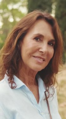 Kameraya bakarken gülümseyen yaşlı güzel kadının yakın çekimi.