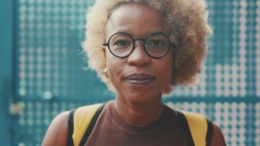 Yaklaş, kadın kameraya bakıp gülümsüyor.