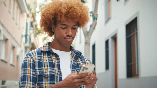 Kerl Mit Afrikanischer Frisur Trägt Blaues Hemd Benutzt Handy Draußen — Stockfoto