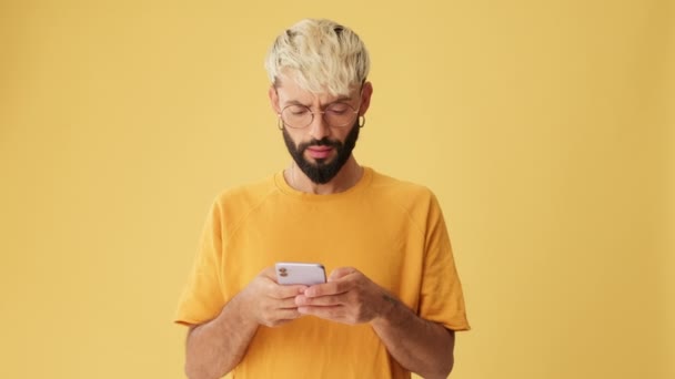 Człowiek Telefonem Rękach Jest Zaskoczony Wow Odizolowany Żółtym Tle Studio — Wideo stockowe