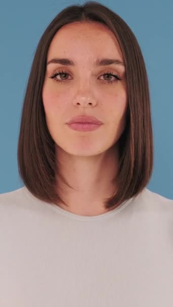 Kapalı Şaşırmış Bir Kadın Büyük Gözlü Kameraya Bakıyor Stüdyoda Mavi — Stok video