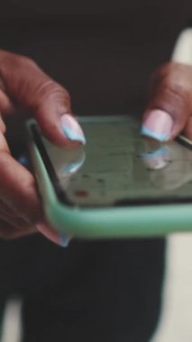 Kamerayla yakın çekim. Elleri telefondan genç kadınların yüzüne doğru hareket ediyor.