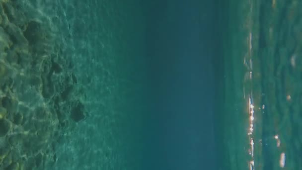 Подводный Выстрел Человек Плавает Размахивая Руками Поверхностью Голубой Воды — стоковое видео