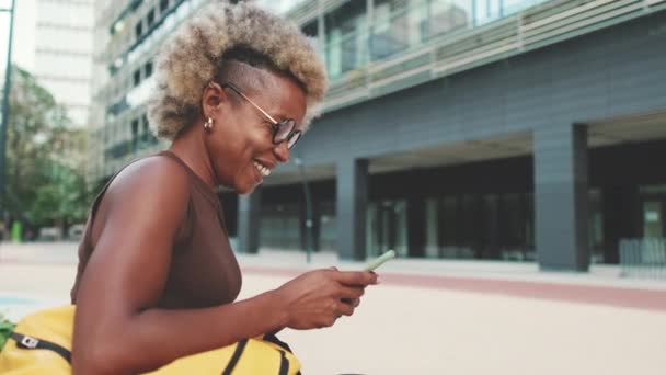 Usmívající Žena Pomocí Mobilního Telefonu Zatímco Sedí Venku — Stock video