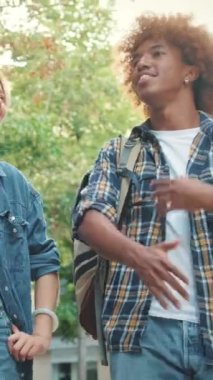 Bir grup arkadaş yürür ve keyifli bir şekilde konuşur, aşağıdan bakarlar.