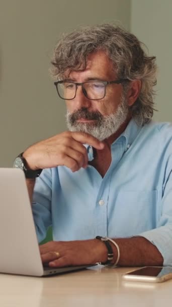 用手提电脑在客厅里戴眼镜的老年人 — 图库视频影像