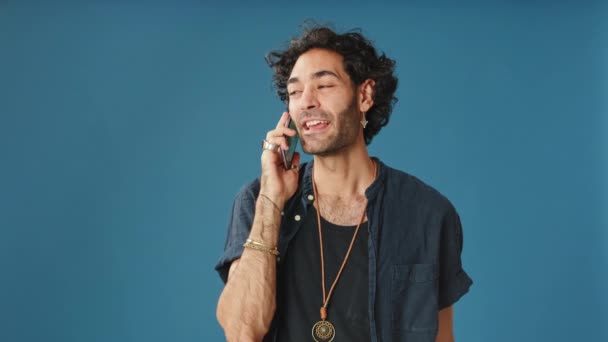 Cep Telefonuyla Konuşan Gülümseyen Adam Stüdyoda Mavi Arka Planda Izole — Stok video