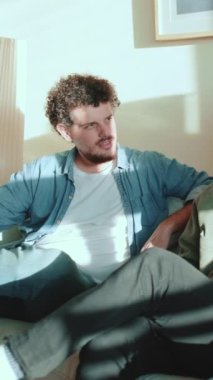 Üç adam evdeki kanepede oturup sohbet ediyor ve iletişim kuruyor.