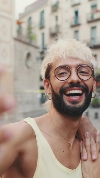 동성애 커플은 포옹을하고 오래된 도시의 거리에 전화에 셀카를 찍는다 — 비디오