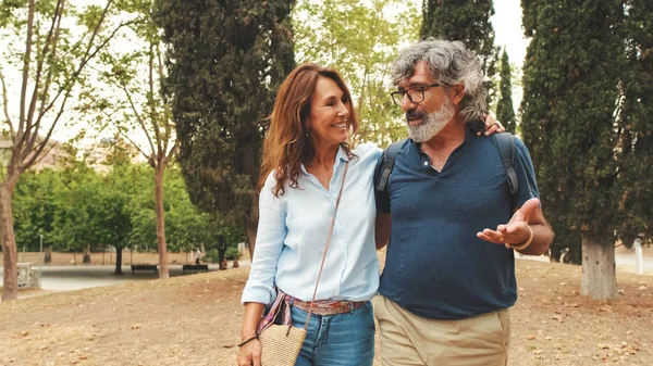 Birbirine aşık yaşlı bir çift parkta yürür ve birbirlerine sarılırlar.