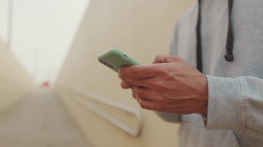 Cep telefonuna SMS yazan orta yaşlı adamın ellerini kapat