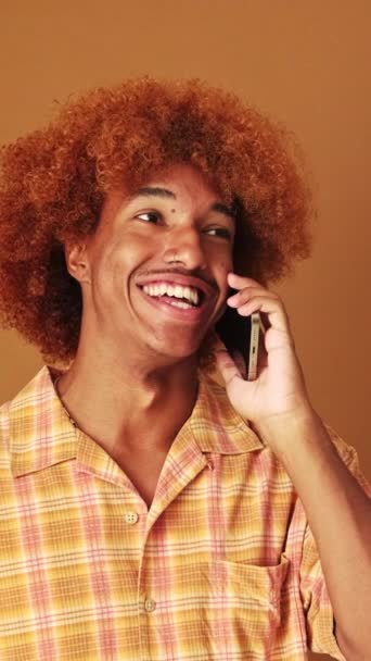Gülen Adam Duygusal Olarak Cep Telefonuyla Konuşuyor Stüdyoda Kahverengi Arka — Stok video