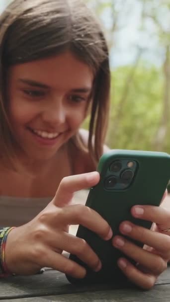 Щаслива Дівчина Підліток Дивиться Відео Мобільний Телефон Сидячи Парку — стокове відео