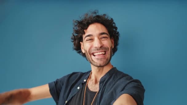 Uśmiechnięty Mężczyzna Patrząc Aparat Robi Selfie Odizolowany Niebieskim Tle Studio — Wideo stockowe