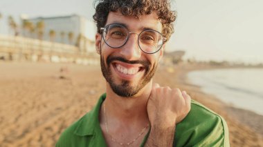 Genç adamın gözlerini açtığı ve kameraya gülümseyerek baktığı yakın plan.