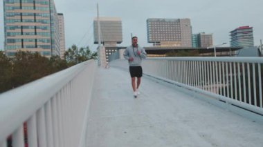 Spor giyimli orta yaşlı bir adam sabah koşusunda.
