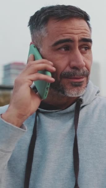 Чоловік Середнього Віку Спортивному Одязі Розмовляє Мобільному Телефоні Стоячи Мосту — стокове відео