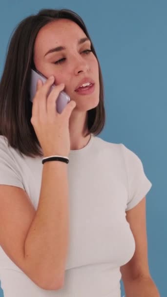 Vihainen Nuori Nainen Puhuu Matkapuhelin Eristetty Sinisellä Taustalla Studiossa — kuvapankkivideo