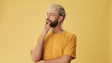 Adam plan yapmayı düşünüyor, bir fikir, iyi bir motivasyonu var, stüdyoda sarı arka planda izole edilmiş.