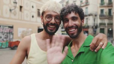 Homoseksüel çift ayakta sarılıyor ve eski şehrin sokaklarında görüntülü arama yapıyor.